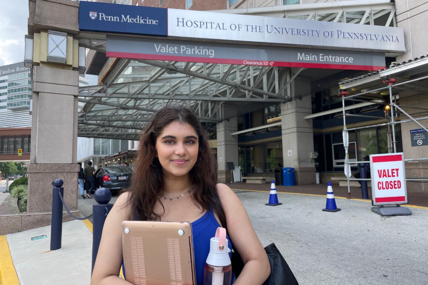 Aarushi Parikh standing in front of the entrance of the Hospital of the University of Pennsylvania