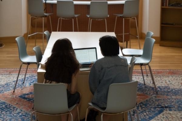 Student and faculty member sitting at a table