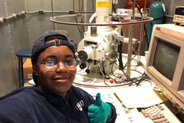 PURM student in front of lab equipment